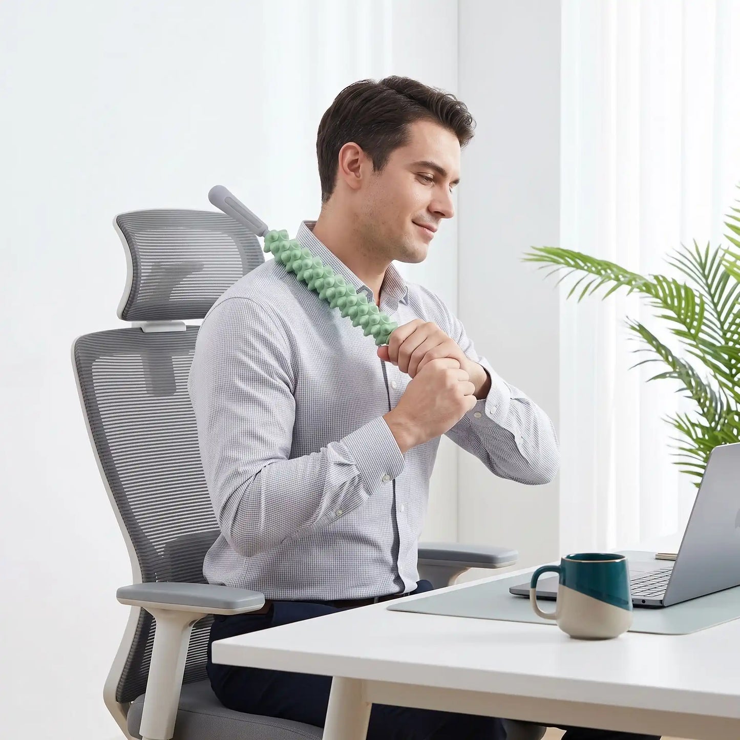 Homme utilise rouleau de massage au bureau