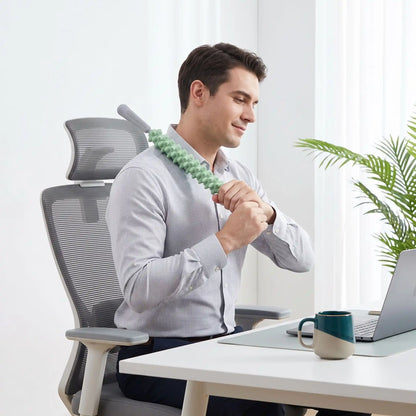 Homme utilise rouleau de massage au bureau