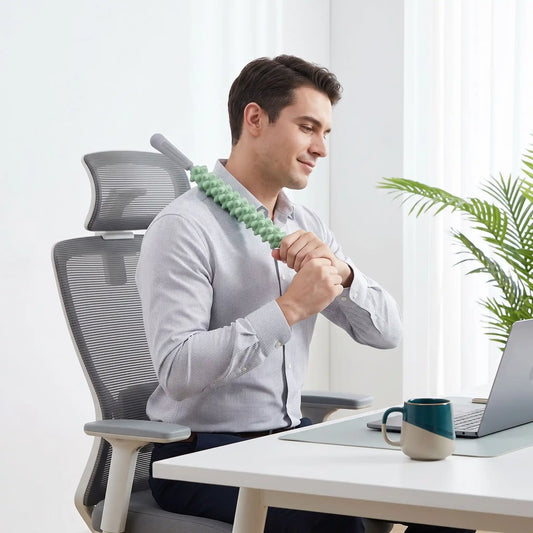 Homme utilise rouleau de massage au bureau